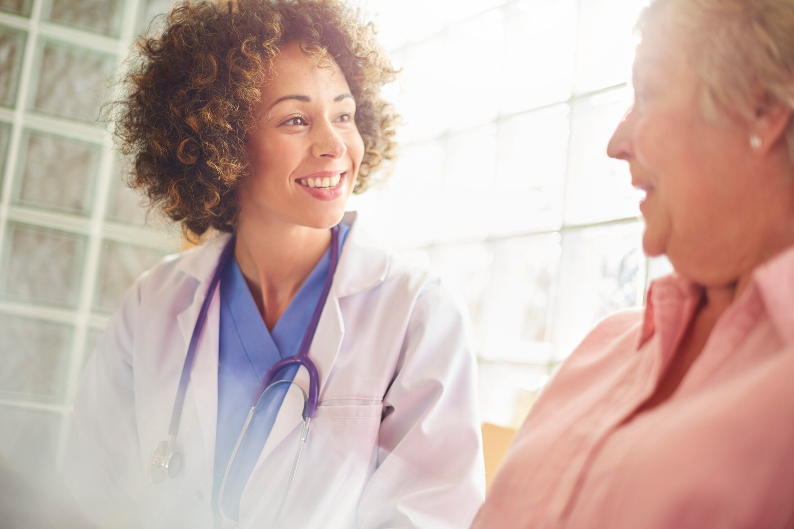 Doctor smiles and talks to elderly female patient