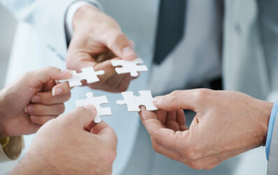 Healthcare professionals putting together the puzzle pieces of value-based care and ACO REACH Model.