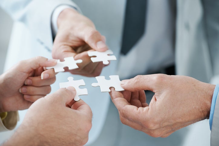 Healthcare professionals putting together the puzzle pieces of value-based care and ACO REACH Model.