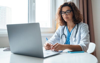 Medical doctor inputting documentation and coding after annual wellness visit with Medicare beneficiary